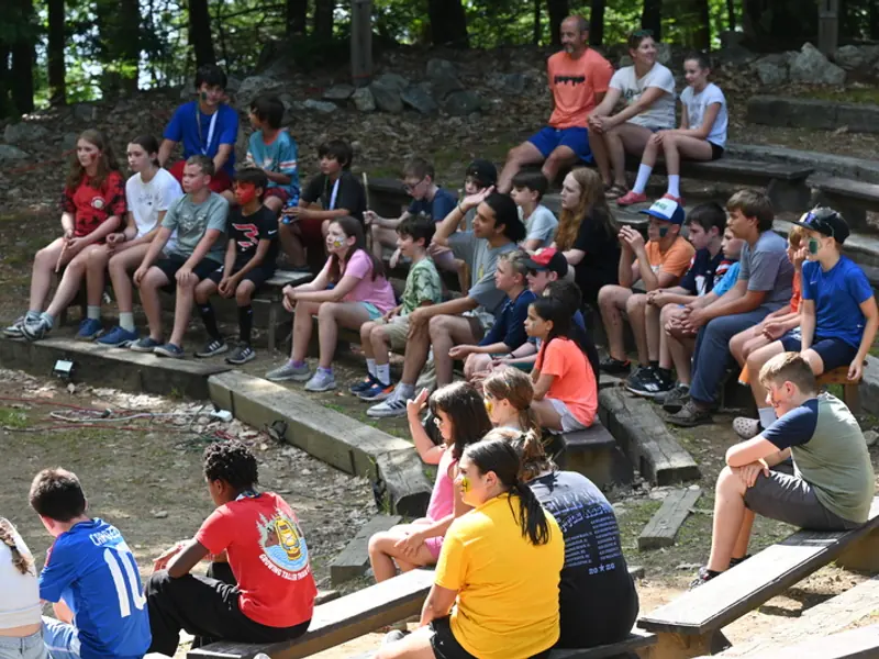 Campers gathered on the stone benches of the outdoor amphitheater