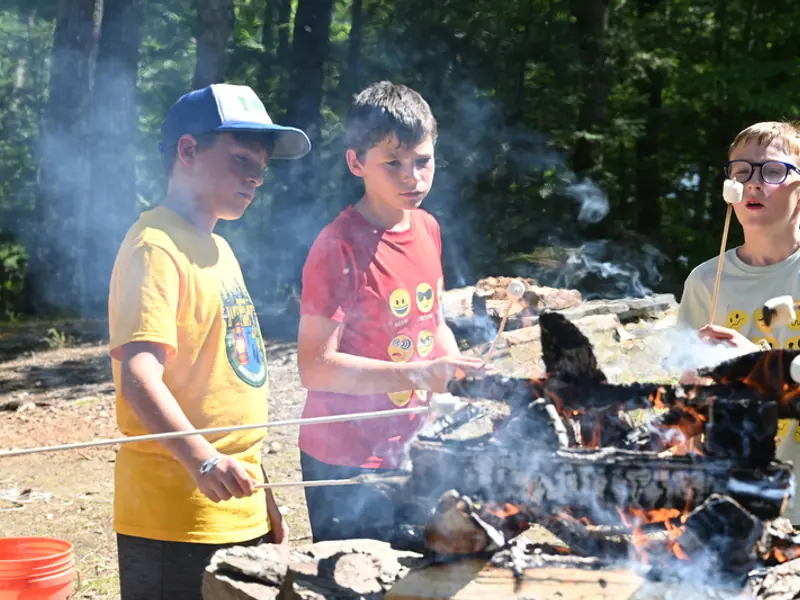 Campers roasting marshmallows over a campfire