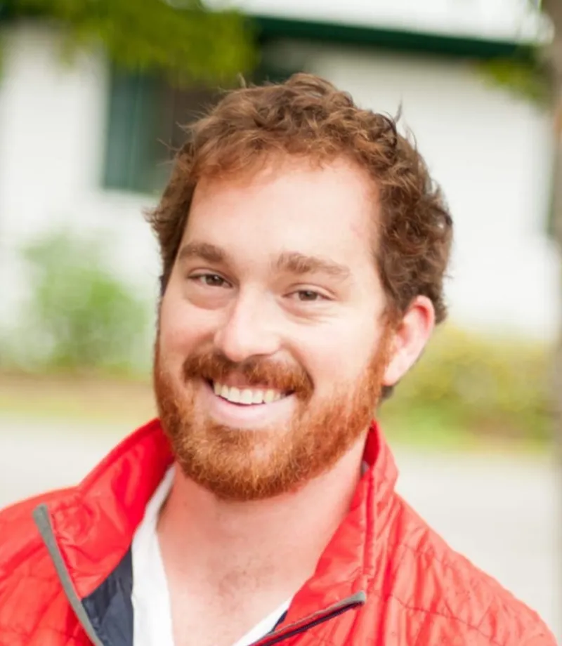 Nick Wood, Camp Director of Lantern Light Camps, smiling outdoors in a red jacket